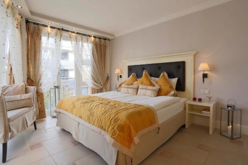 a bedroom with a large bed and a chair at Boutiquehotel La Casa in Tübingen