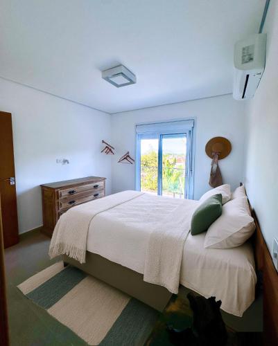 a bedroom with a large bed and a window at Juquehy - Duplex in prime area 1 block from the beach in Juquei