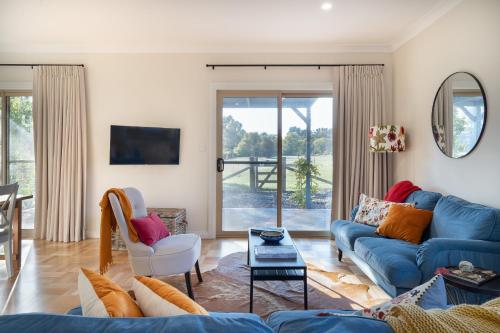 a living room with a blue couch and a table at Alderwood Cottage - Heart of The Highlands in Glenquarry