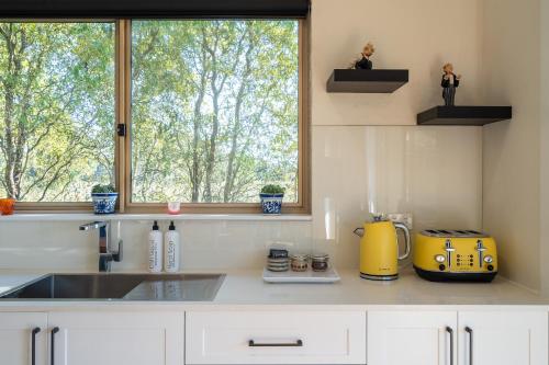 a kitchen counter with a sink and a window at Alderwood Cottage - Heart of The Highlands in Glenquarry