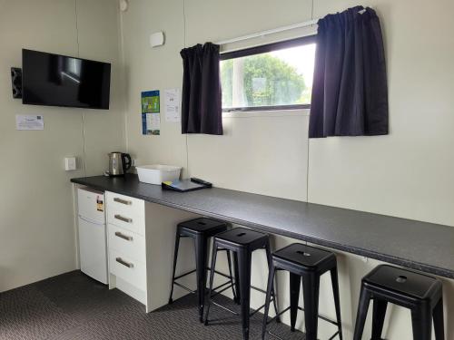 a kitchen with a counter with stools in a room at Levin TOP 10 Holiday Park in Levin