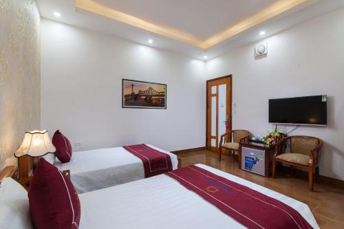 a hotel room with two beds and a flat screen tv at Luxury Airport Hotel - Convenient & Friendly in Hanoi