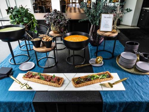 a table with sandwiches and a bowl of soup at Novotel Chennai Chamiers Road in Chennai