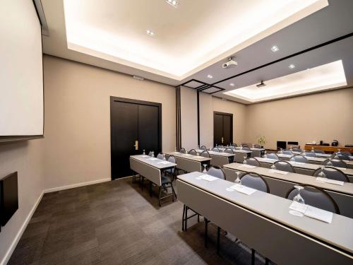 a room with rows of tables and chairs at Grand Mercure SP Itaim Bibi in São Paulo