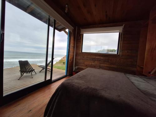 a bedroom with a bed and a view of the ocean at Departamento en la Playa Pura Vida MDQ in Mar del Plata