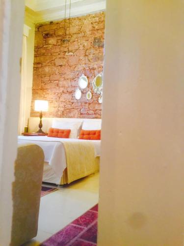 a bedroom with a bed and a brick wall at Cunda Adali Pansiyon in Ayvalık