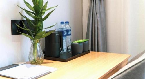 a desk with a vase and water bottles on it at GreenTree Inn Express Datong High-Speed Railway Station Old City Wall in Datong