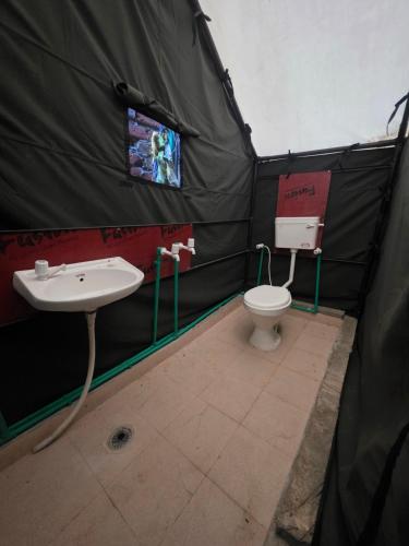 a bathroom with a sink and a toilet in a tent at Jalpa Camp Kasol in Kulu