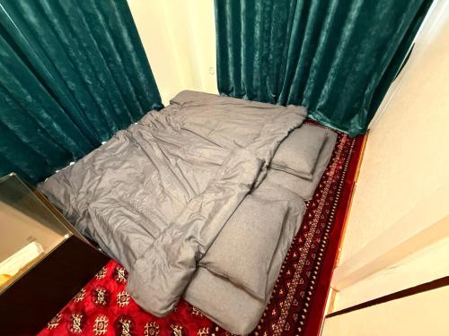 Bett in einem Zimmer mit grünen Vorhängen in der Unterkunft SUN PALACE Fussa in Fussa
