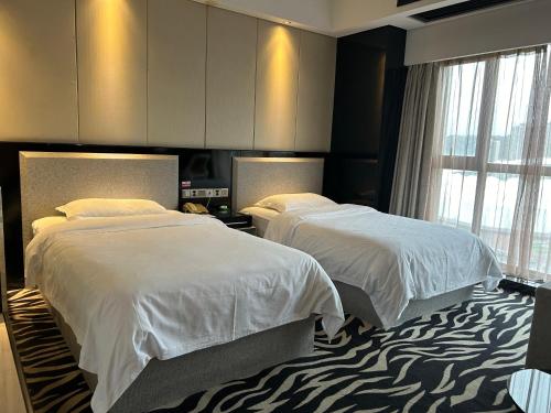 a hotel room with two beds and a large window at Zhangjiajie Merlot Crystal Hotel in Zhangjiajie