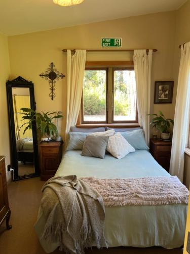a bedroom with a large bed with a window at Quaint Country Cottage 