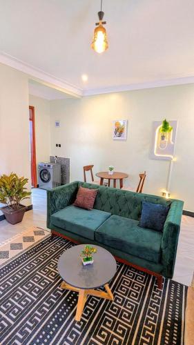 a living room with a green couch and a table at Ahwera beautiful homes in Kampala
