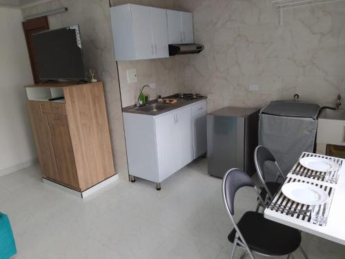 a kitchen with a sink and a table and chairs at Apartaestudios Llano Grande 2 in Palmira