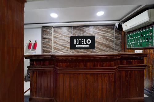 a wooden bar with a sign on top of it at Hotel O Alappuzha Near General Hospital Junction in Alleppey