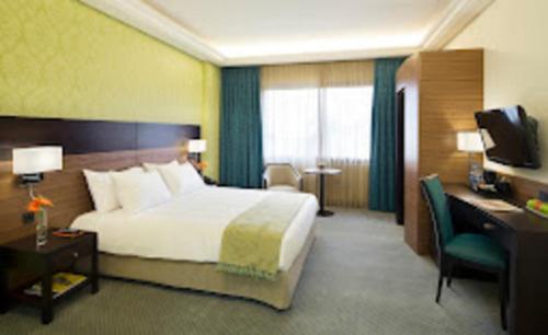 a hotel room with a large bed and a desk at Marasina hotel j in Aqaba