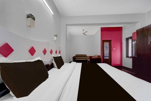 a bedroom with a large bed with black and white sheets at Hotel O Alappuzha Near General Hospital Junction in Alleppey