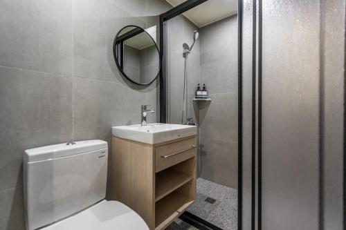 a bathroom with a toilet and a sink and a mirror at Hotel Ever Spring - Penghu in Magong