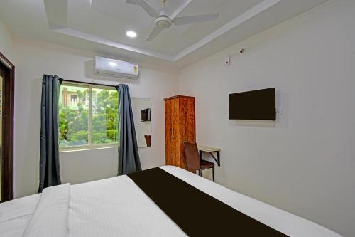 a bedroom with a bed and a window and a desk at Super Collection O White Field Road Hyderabad Formerly Ayaan Signature Suites in Kondapur