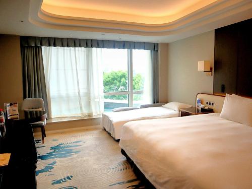 a hotel room with two beds and a window at Oriental Riverside Bund View Hotel (Shanghai International Convention Center) in Shanghai