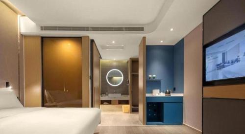 a bedroom with a bed and a flat screen tv at Atour Hotel Taiyuan Inner Ring in Taiyuan