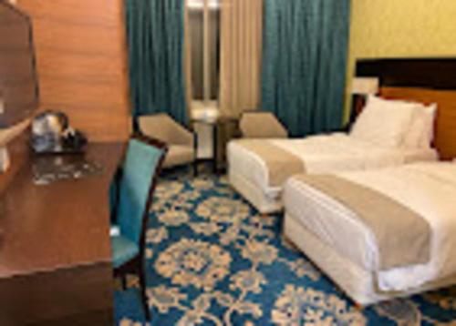 a hotel room with two beds and a desk at Marasina hotel j in Aqaba