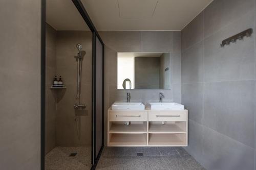 a bathroom with two sinks and a shower at Hotel Ever Spring - Penghu in Magong