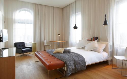 una camera con un letto, una sedia e un tavolo di B2 Hotel Zürich a Zurigo