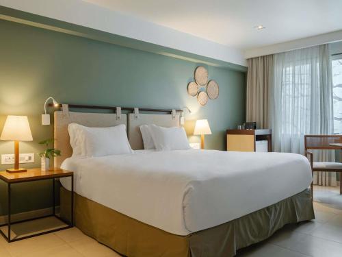 a large bed in a hotel room with a large bed at Grand Mercure Rio de Janeiro Copacabana in Rio de Janeiro