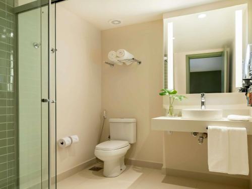 a bathroom with a toilet and a sink and a shower at Grand Mercure Rio de Janeiro Copacabana in Rio de Janeiro