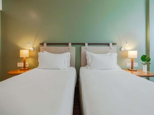 two beds sitting next to each other in a room at Grand Mercure Rio de Janeiro Copacabana in Rio de Janeiro