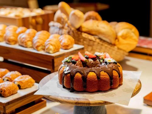 a chocolate bundt cake on a table with other pastries at Grand Mercure Rio de Janeiro Copacabana in Rio de Janeiro