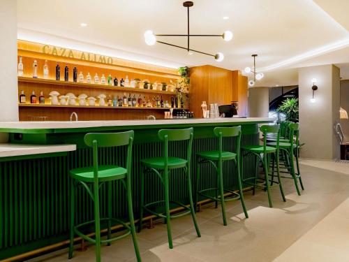 a green bar in a restaurant with green stools at Grand Mercure Rio de Janeiro Copacabana in Rio de Janeiro