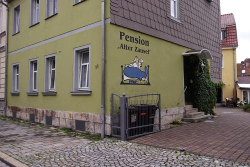 un edificio amarillo con un cartel en el costado en Pension Alter Zausel, en Weimar