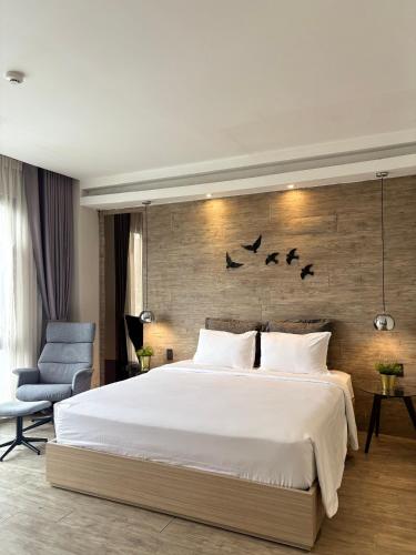 a bedroom with a large bed and birds on the wall at The Luxe Da Lat in Da Lat