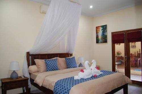 a bedroom with a bed with two stuffed animals on it at Beachfront Villa Jepun Segara in Banjar