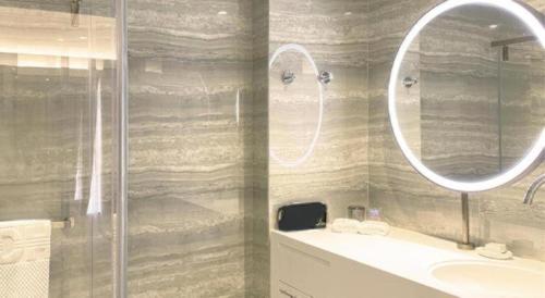 a bathroom with a shower and a sink and a mirror at OASIS AVENUE-A GDH HOTEL in Hong Kong