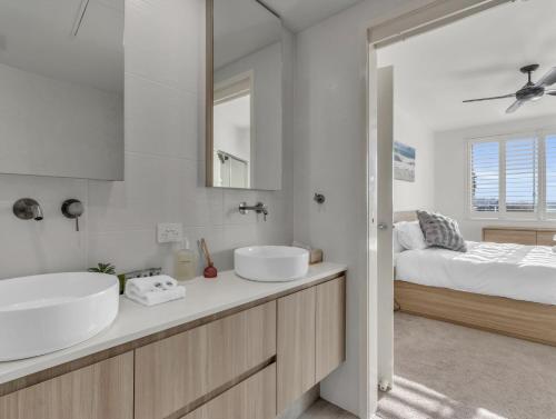 a white bathroom with two sinks and a bed at Drift North Beachfront Apartments - Private Apartments in Kingscliff