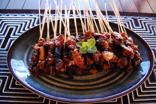 a plate of food on a plate with chop sticks at Beachfront Villa Jepun Segara in Banjar