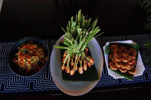 a table with two plates of food and a bowl of food at Beachfront Villa Jepun Segara in Banjar