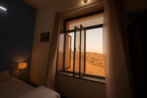 Un dormitorio con una ventana con vista al desierto. en Pushkar Story Homestay, en Pushkar