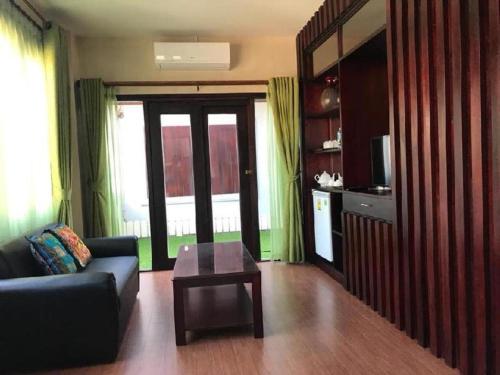 a living room with a couch and a coffee table at Saysamphanh Hotel in Ban Nongkham