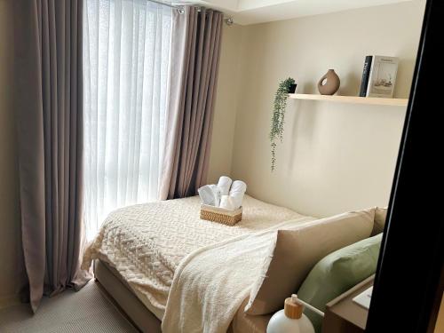 a bedroom with a bed with a window at Kasara Urban Residences in Pasig City - Solmera Cove in Manila
