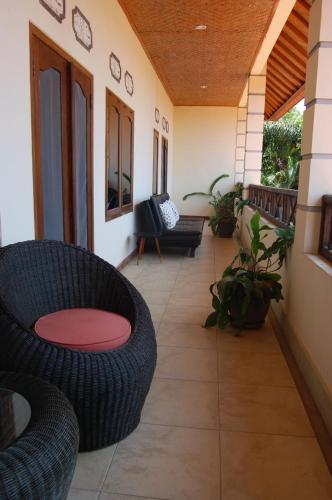 a porch with a couch and chairs on a house at Beachfront Villa Jepun Segara in Banjar