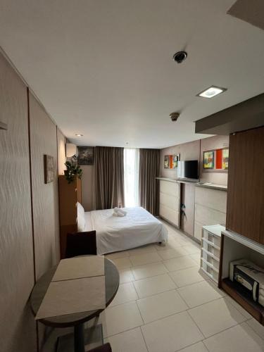 a hotel room with a bed and a table at Antel Spa Residences 10EE in Manila