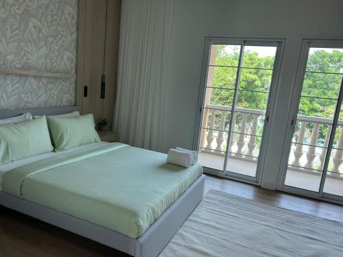 a bedroom with a white bed with two windows at Architect Designed house 2 BR with Private Pool in Dubai