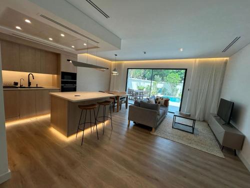 a kitchen and living room with a table and a couch at Architect Designed house 2 BR with Private Pool in Dubai