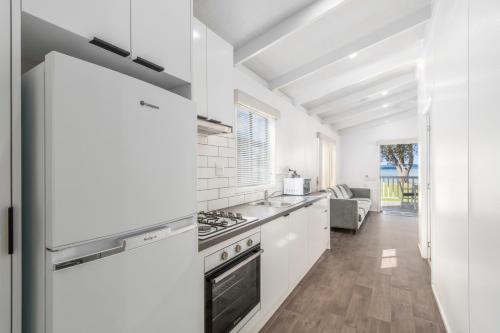 a kitchen with white cabinets and a stove top oven at Ingenia Holidays Eden Beachfront in Eden