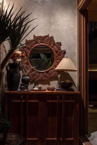 a mirror on top of a dresser with a lamp at D'Santai Villas in San Juan