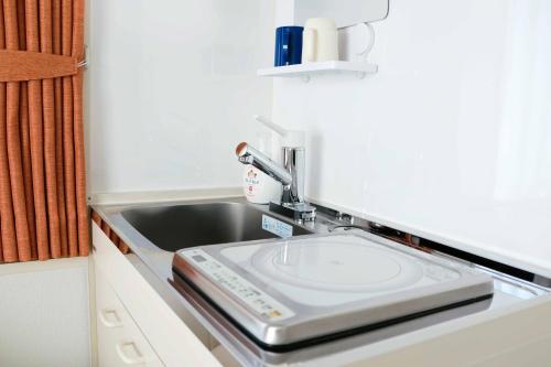 a kitchen counter with a sink and a sink at Hananoie華之家 in Tokyo