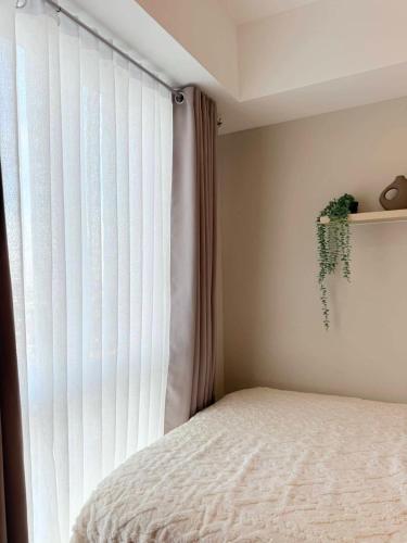 a bedroom with a bed and a large window at Kasara Urban Residences in Pasig City - Solmera Cove in Manila